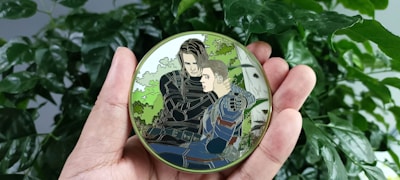 Hands holding a freshly printed album with a glossy cover showing a local tournament logo.