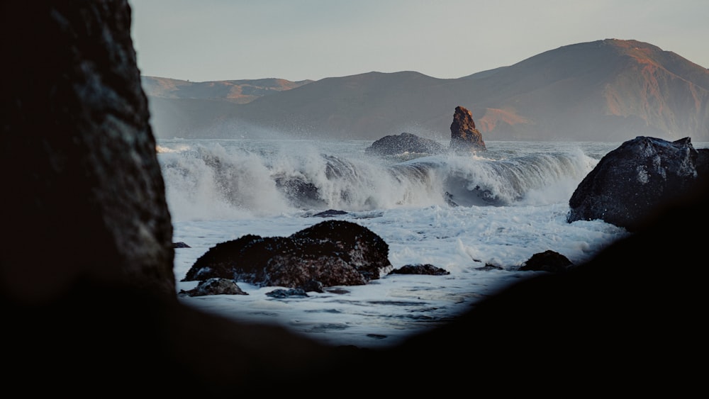 a rocky beach with a large body of water in the middle