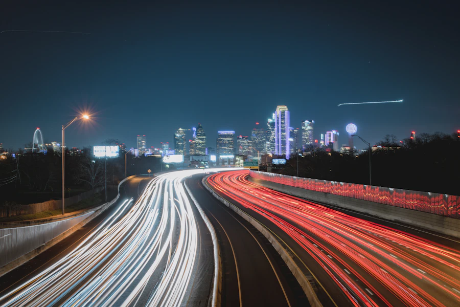 Highway at night with the Dallas city skyline illuminated in the background