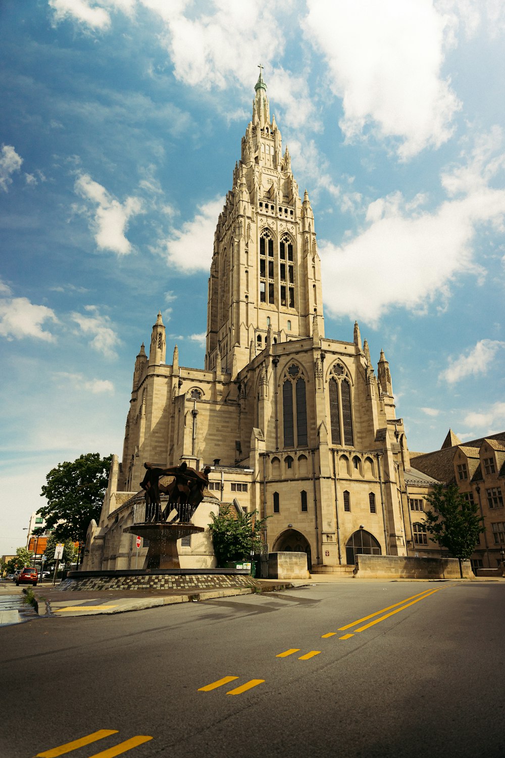 a large stone building with a statue in front of it with University Church of St Mary the Virgin in the background