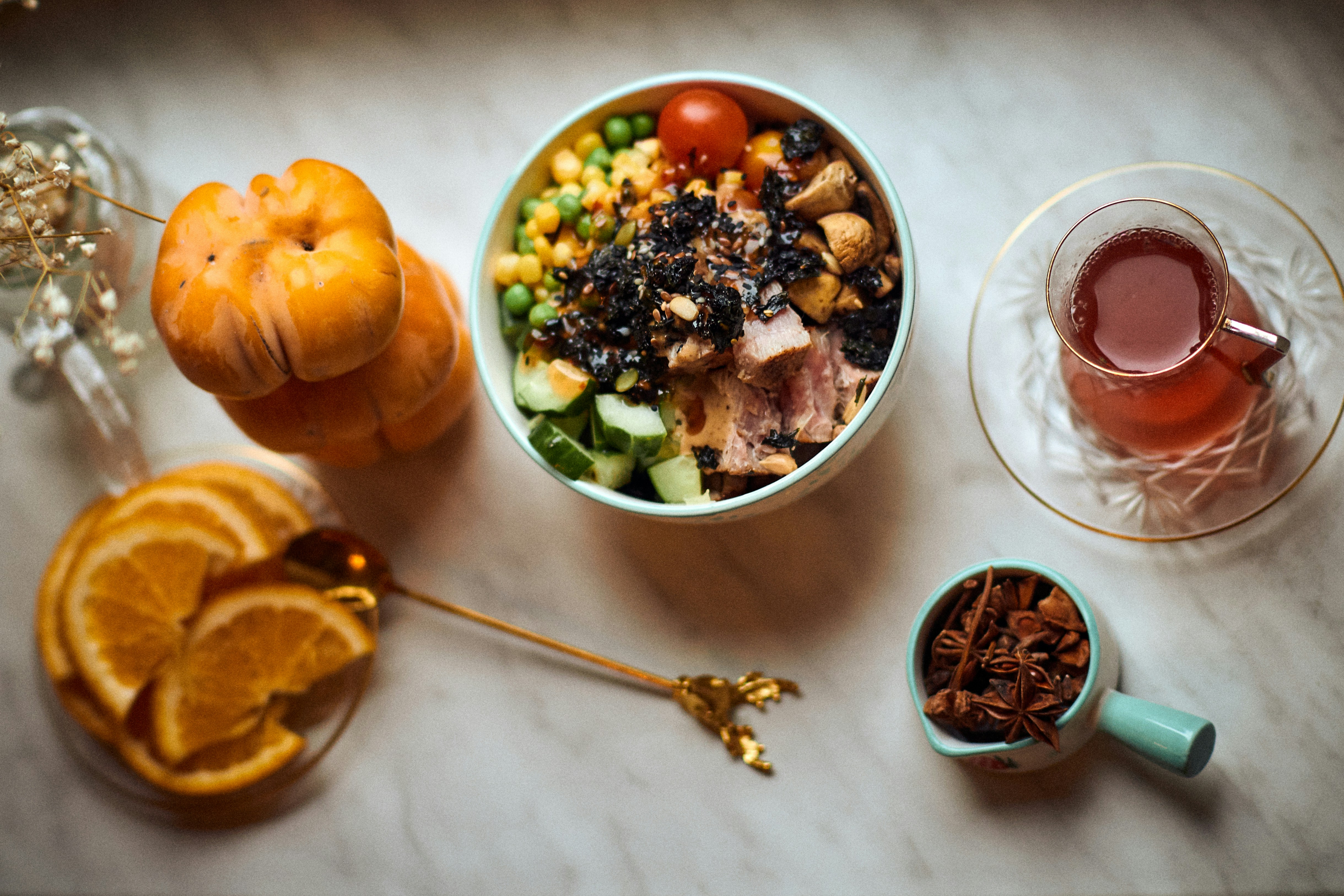 Grain bowl beside tea and orange slices