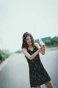 a woman holding a drink and a can