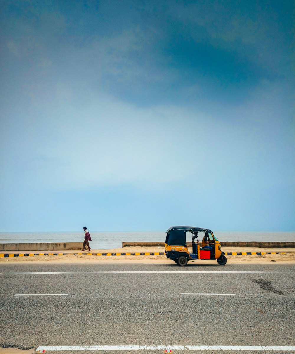 a person standing next to a yellow van on a road