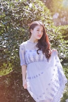 A model wearing a flowing organic cotton dress in a natural setting.