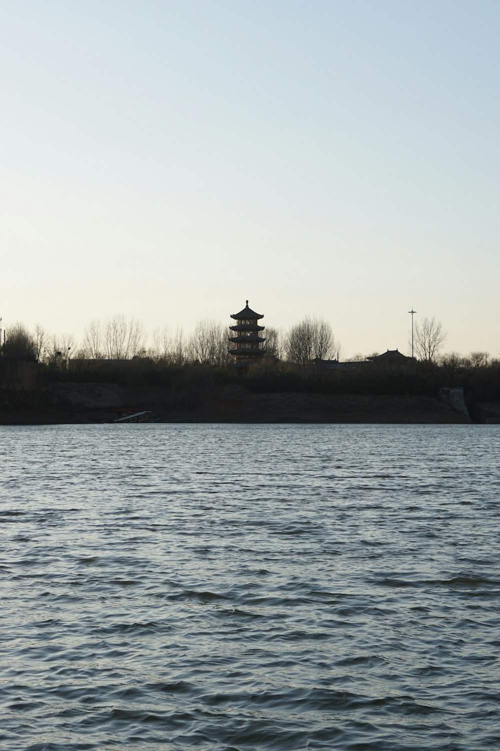 a body of water with a building on the shore