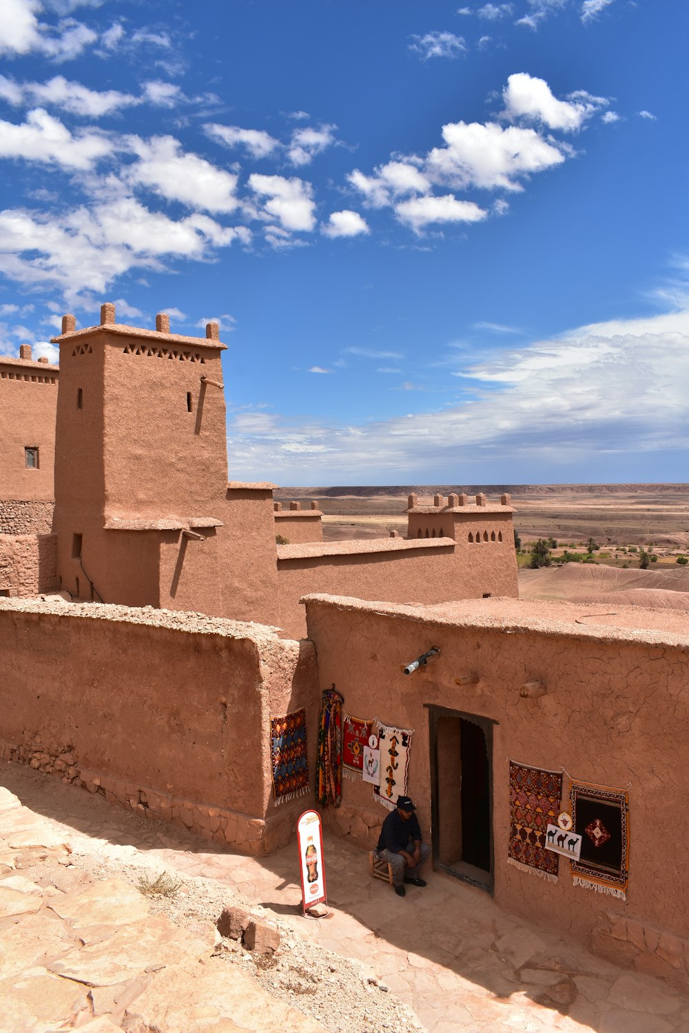 a person sitting on a wall with Tiwanaku in the background