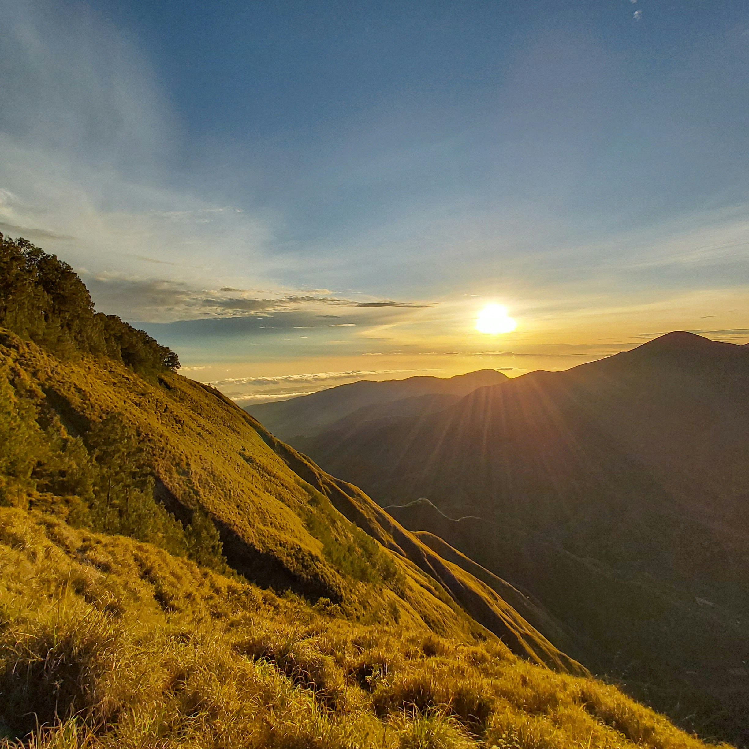 a landscape with hills and a body of water in the distance