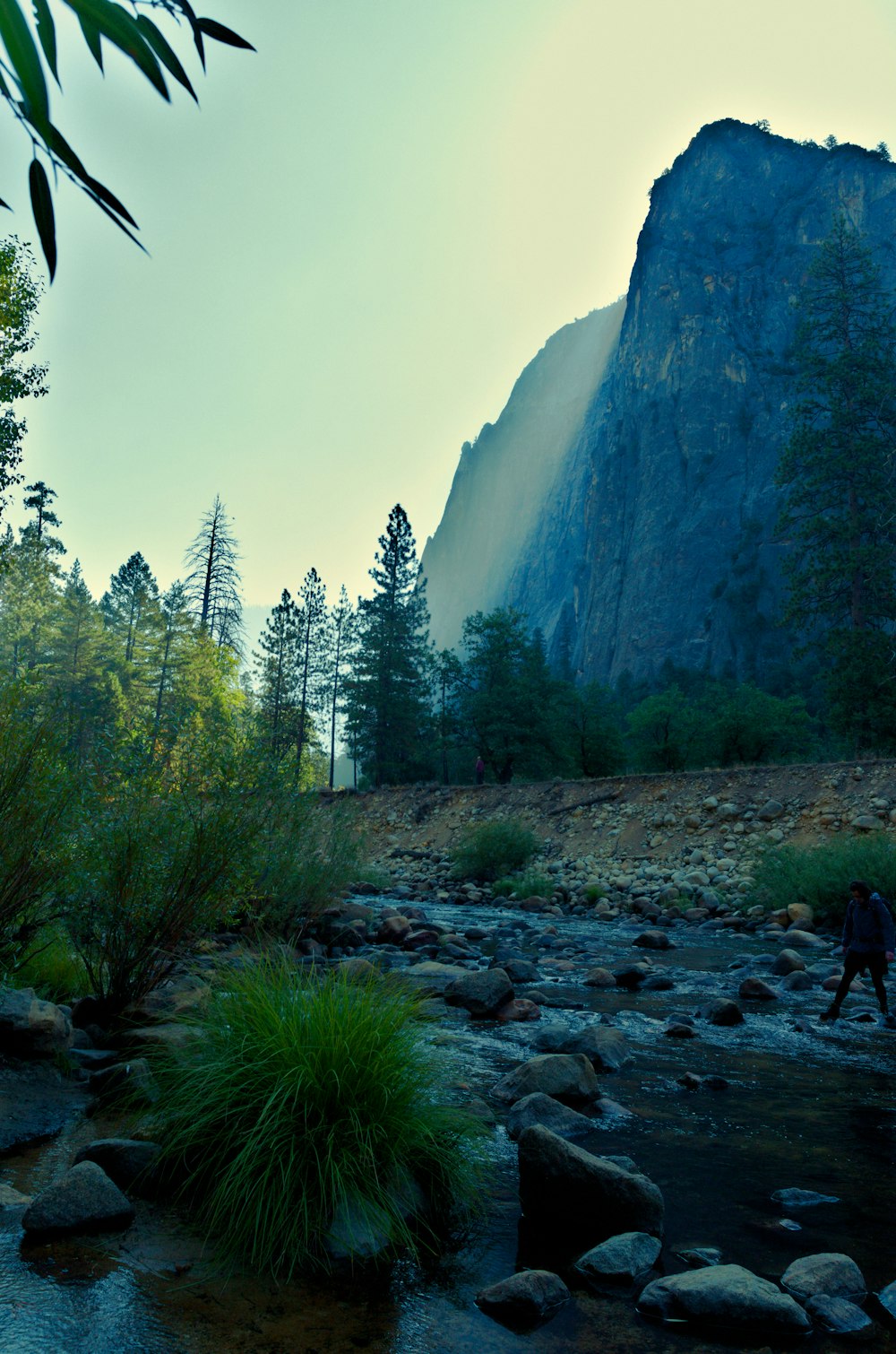 a person walking on a rocky path near a waterfall