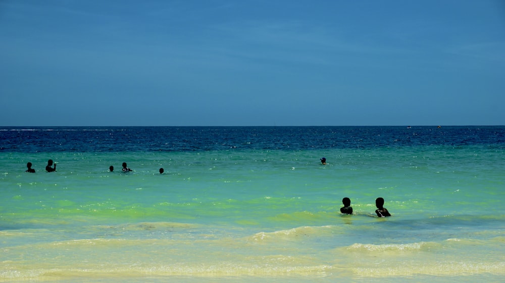 a group of people swimming in the ocean