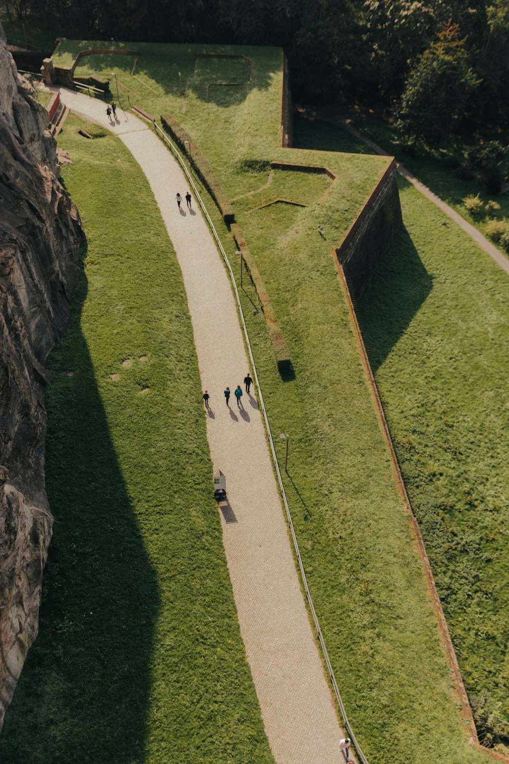 a group of people walking on a path next to a river