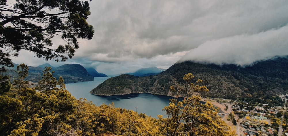 a body of water surrounded by trees and mountains