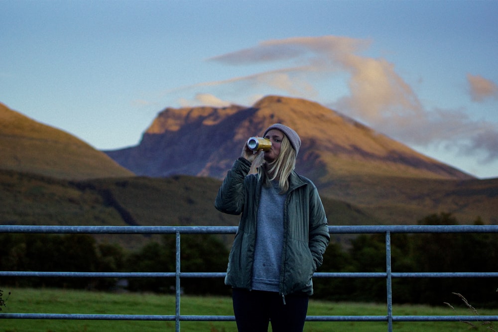 a person taking a picture of a rainbow in the background