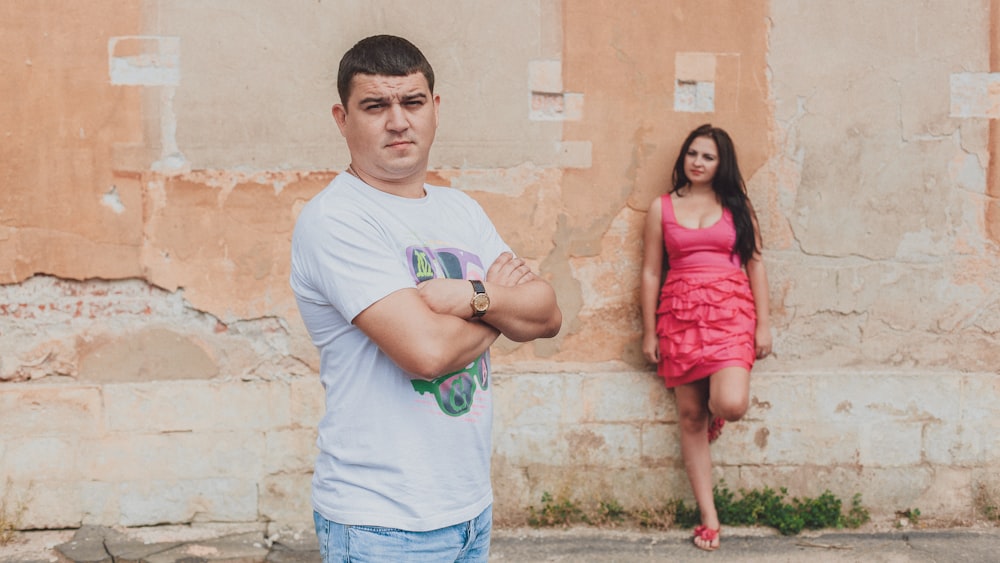 a person with the arms crossed and a girl standing by him