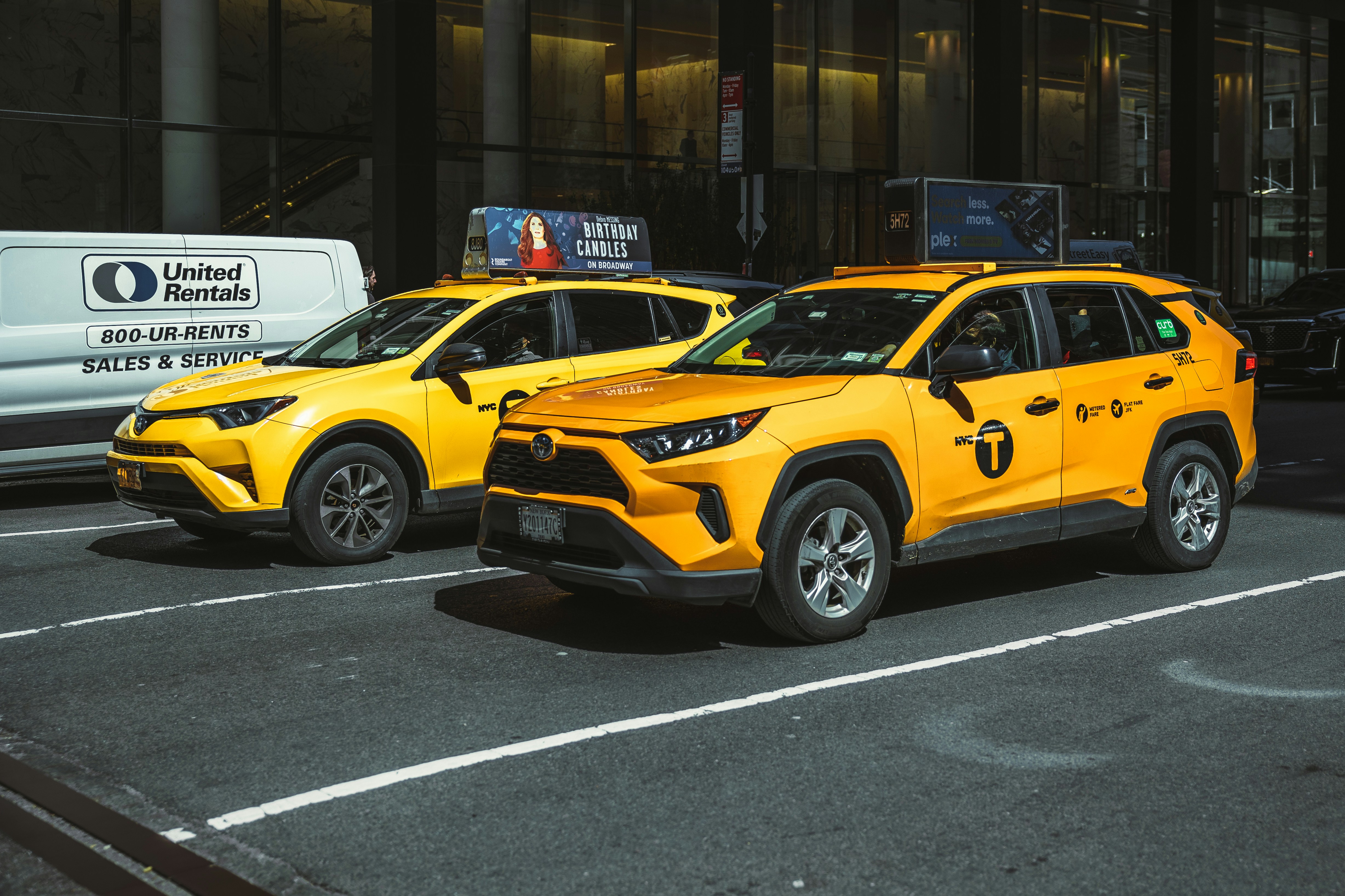 a couple of yellow cars parked in a parking lot