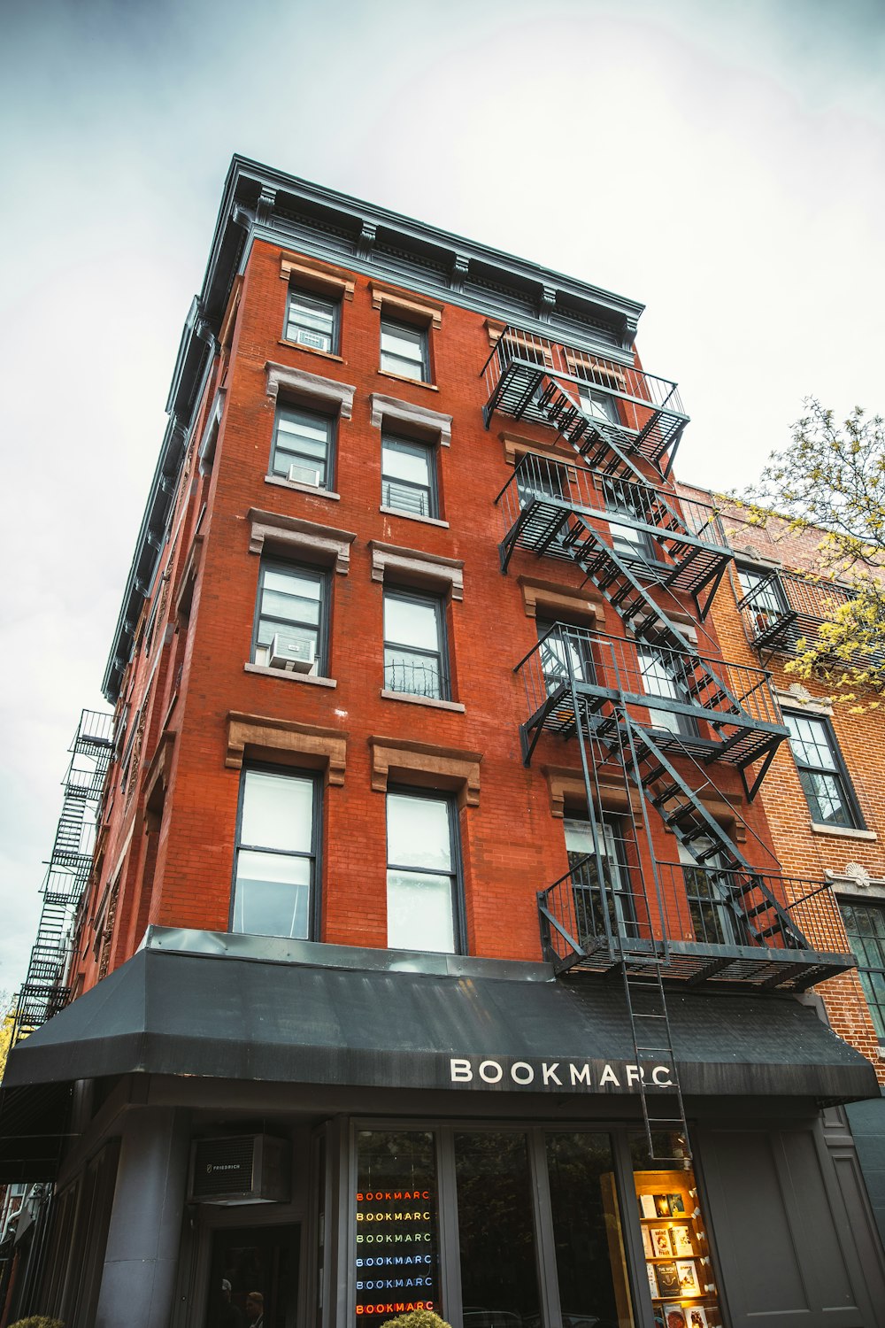 a building with a few balconies and a tree in the background