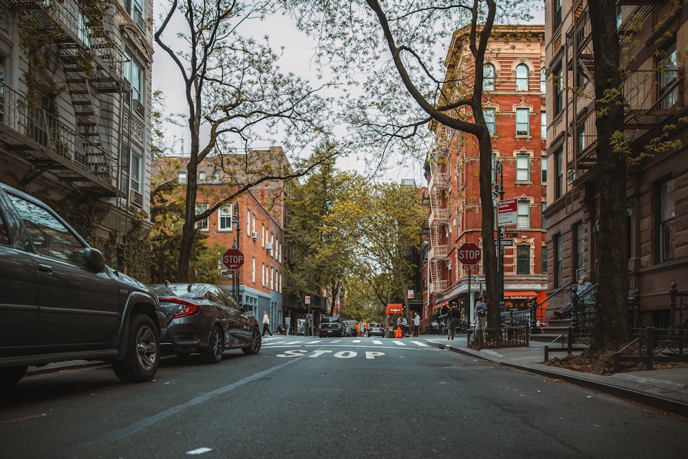 a street with cars and buildings on either side of it with Greenwich Village in the background