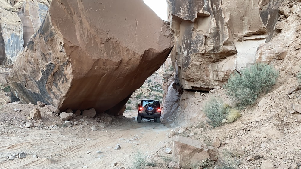 a red car driving through a canyon