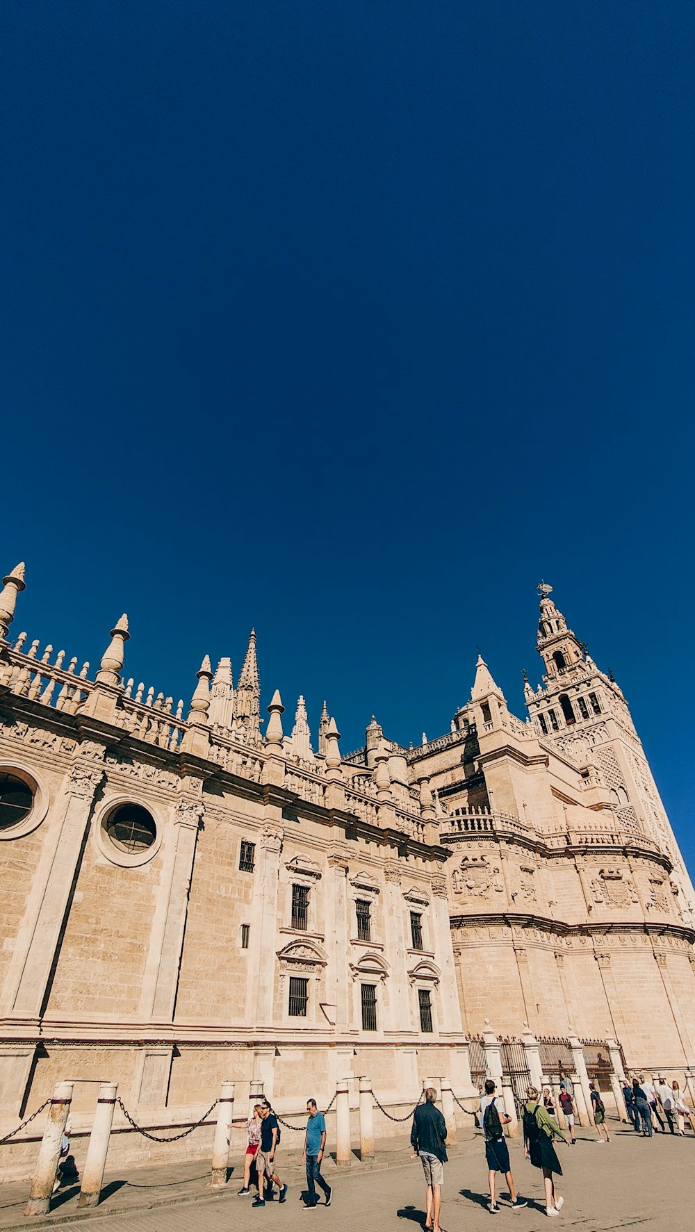 a large stone building with people walking around