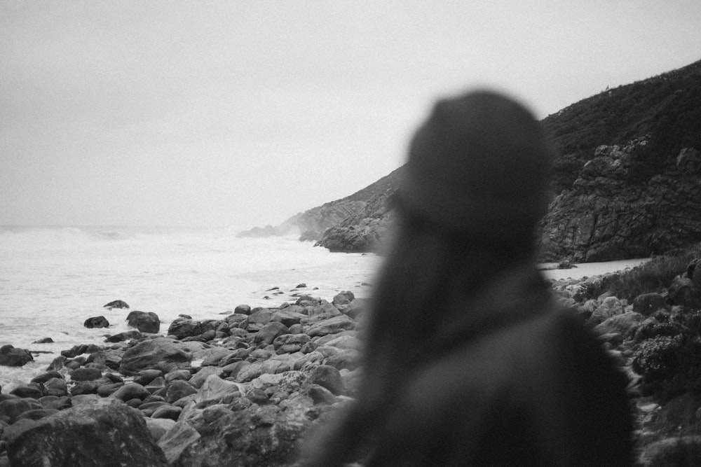 a person standing on a rocky beach