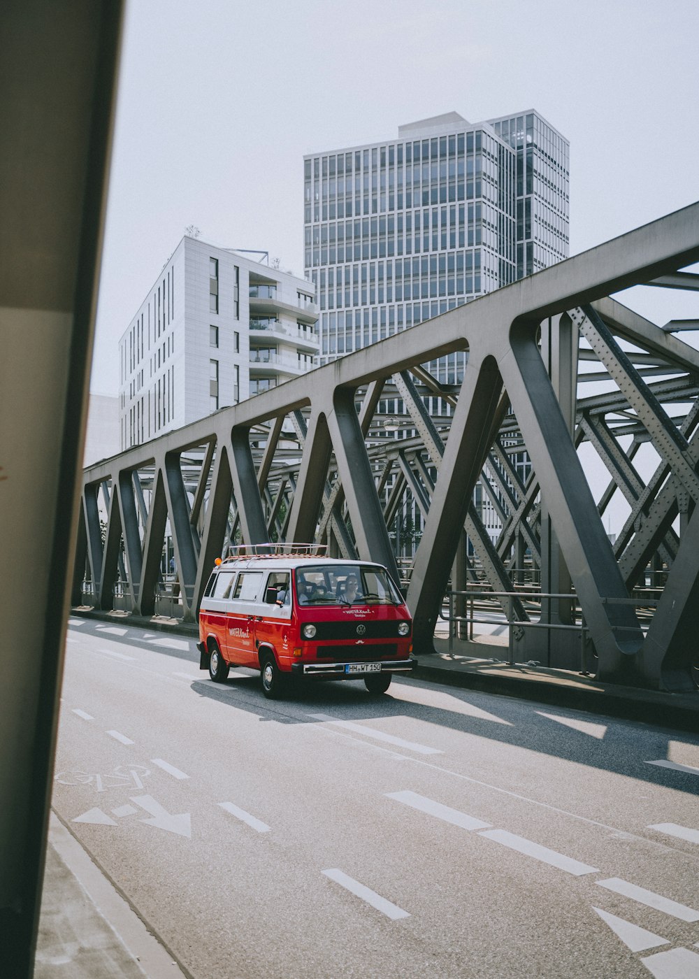 a red truck driving on a bridge