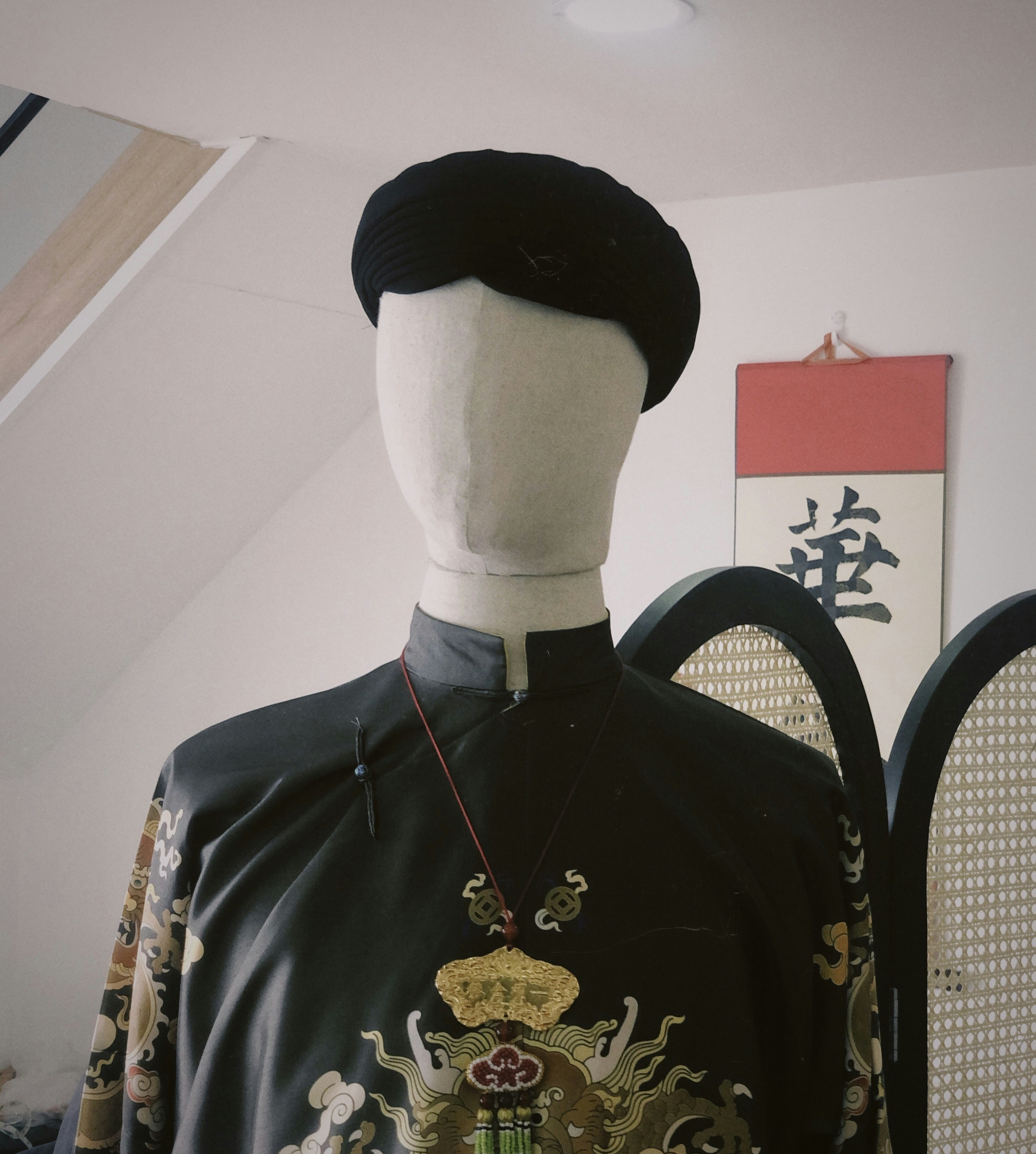 a mannequin wearing a black and white dress and a black hat