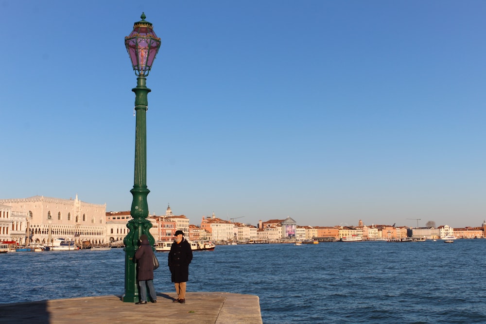 a group of people standing on a dock by a body of water