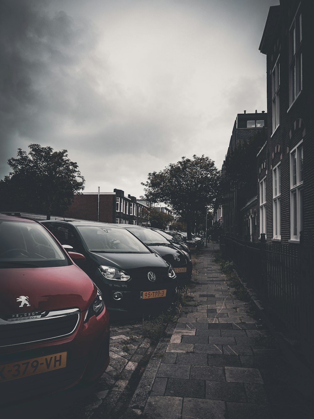 a row of cars parked on a brick road