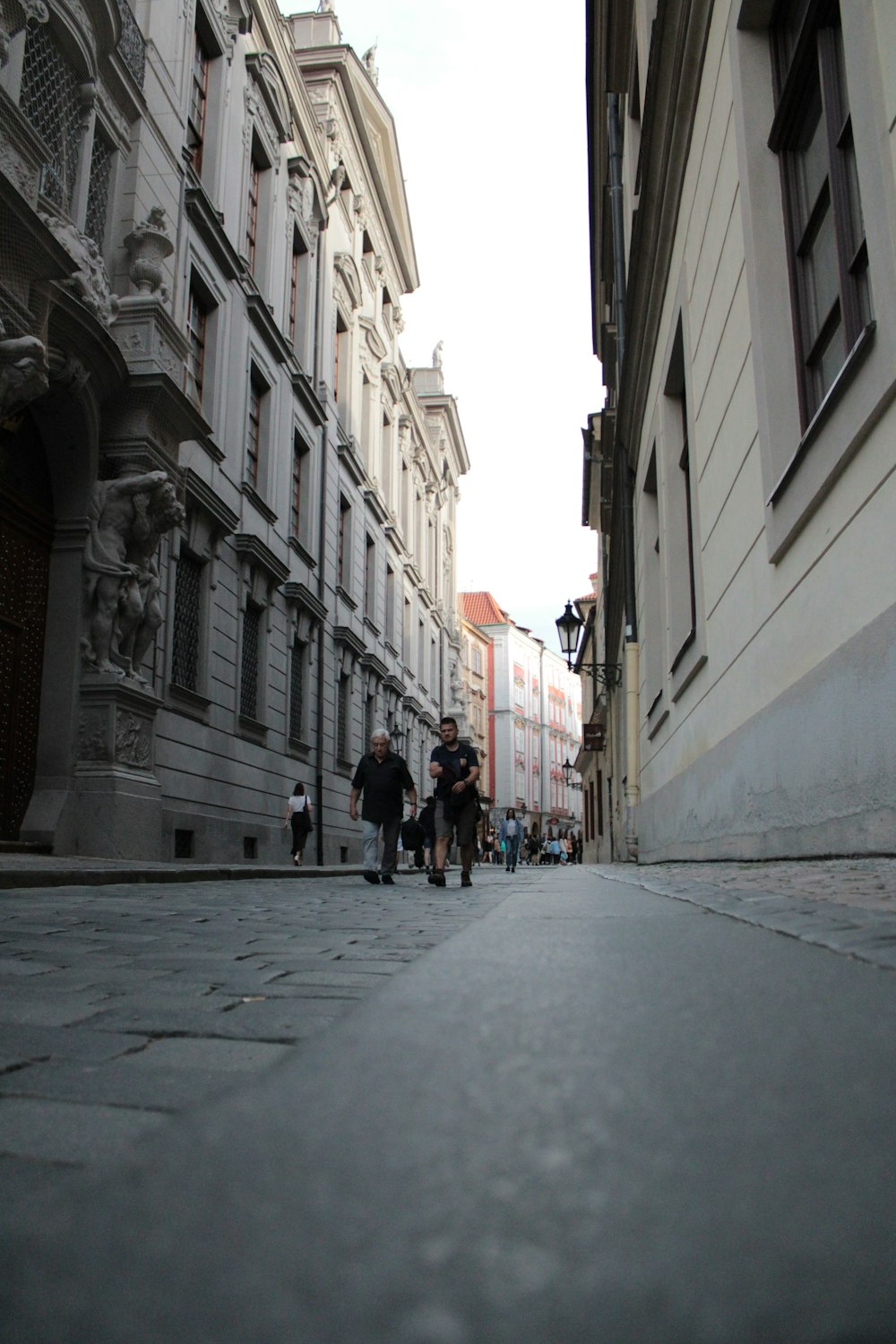 people walking on a street between buildings