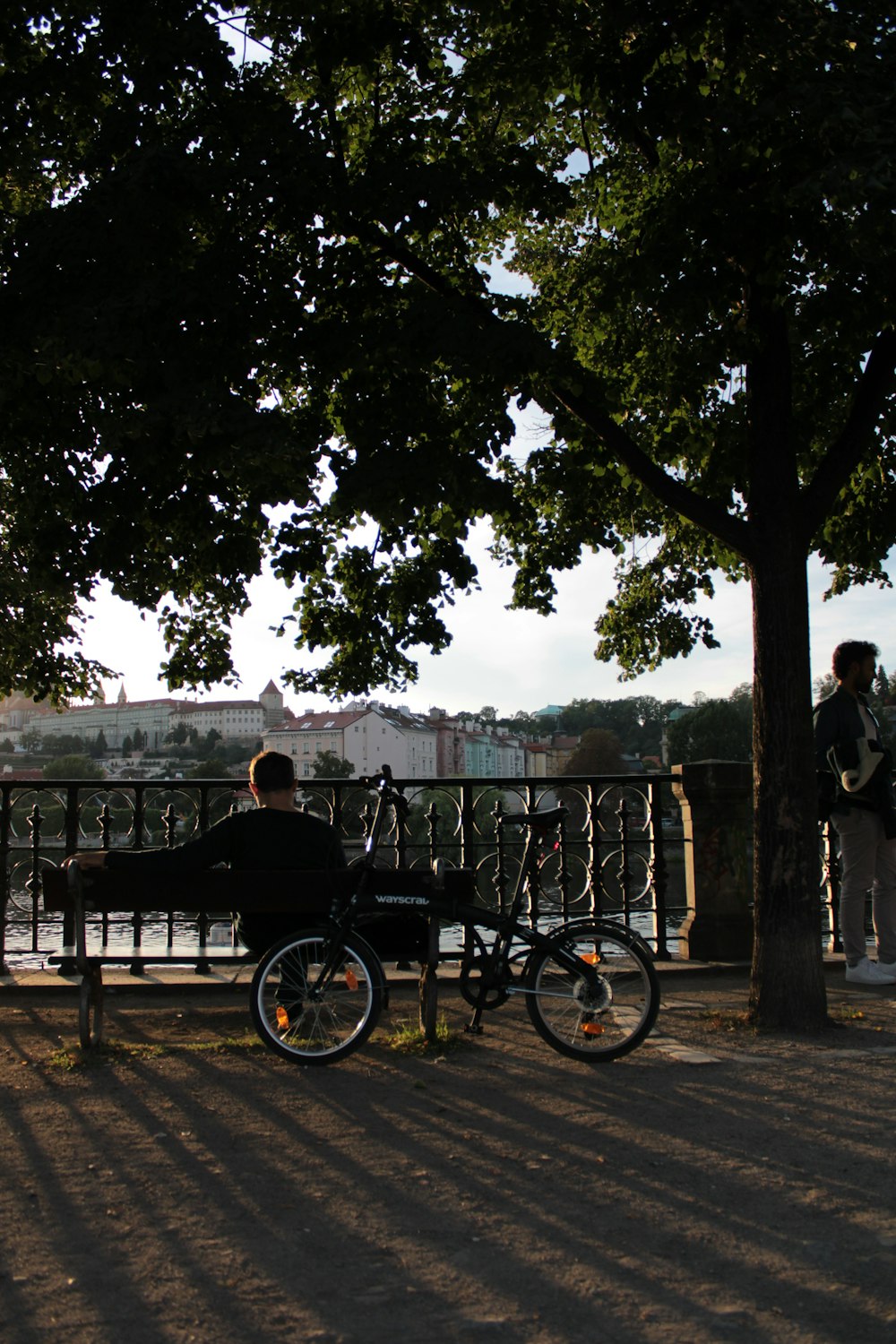a person sitting on a bench next to a bicycle
