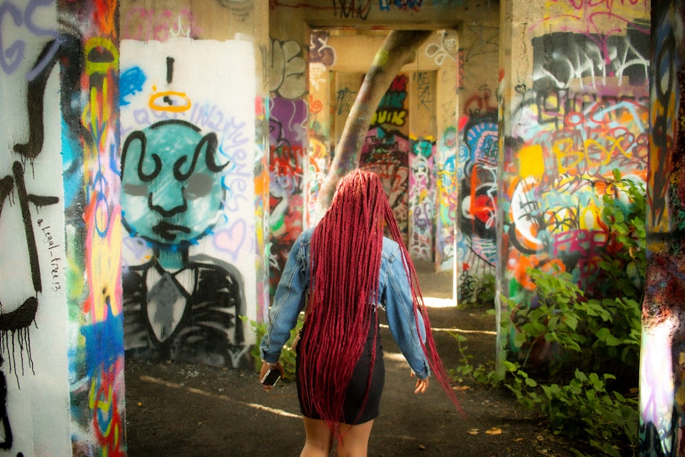 a person walking in front of a wall covered in graffiti