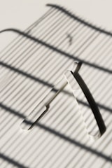 Close-up of sharp razor blades neatly arranged on a wooden surface, highlighting their precision and quality.