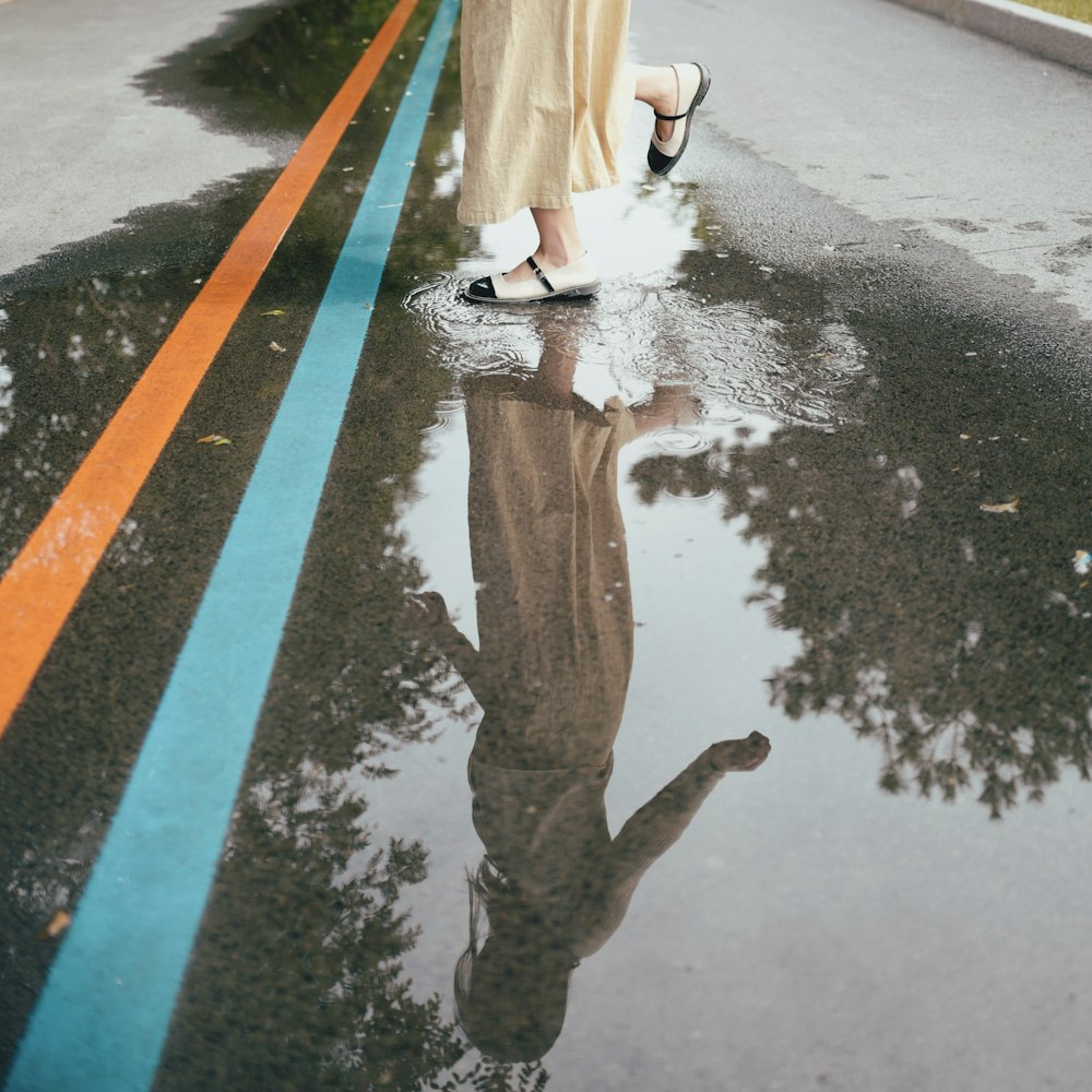 a person standing on a wet sidewalk