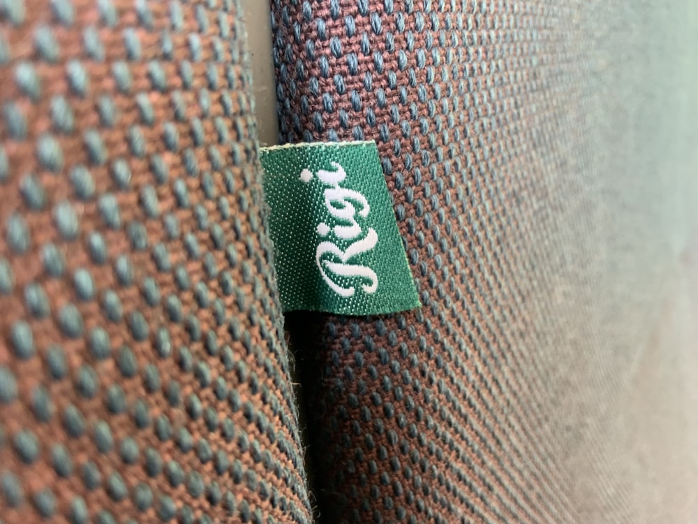 a green and black zipper on a brown leather jacket