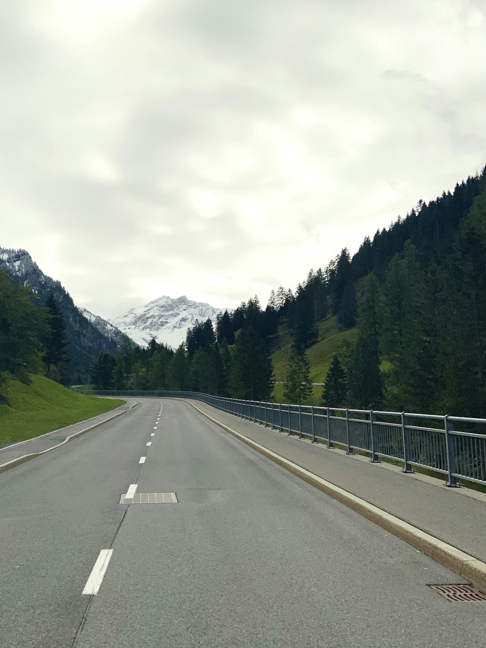 a road with trees and mountains in the background