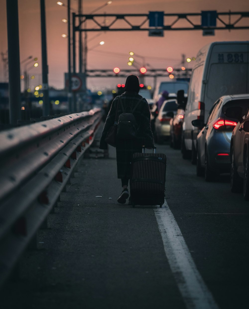 a person with a suitcase walking down a sidewalk