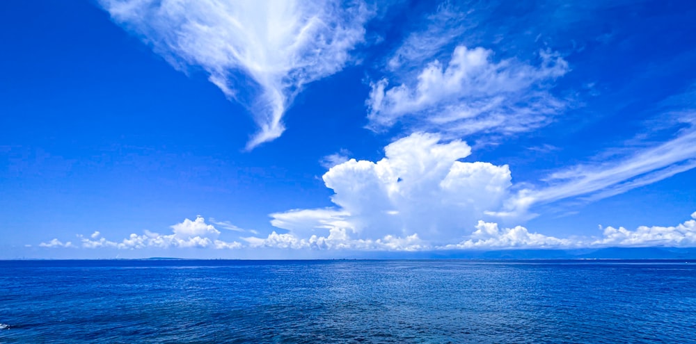 a body of water with clouds above it