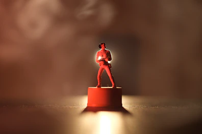 Sleek 3D-printed decorative figurine illuminated by soft orange neon light on a dark background