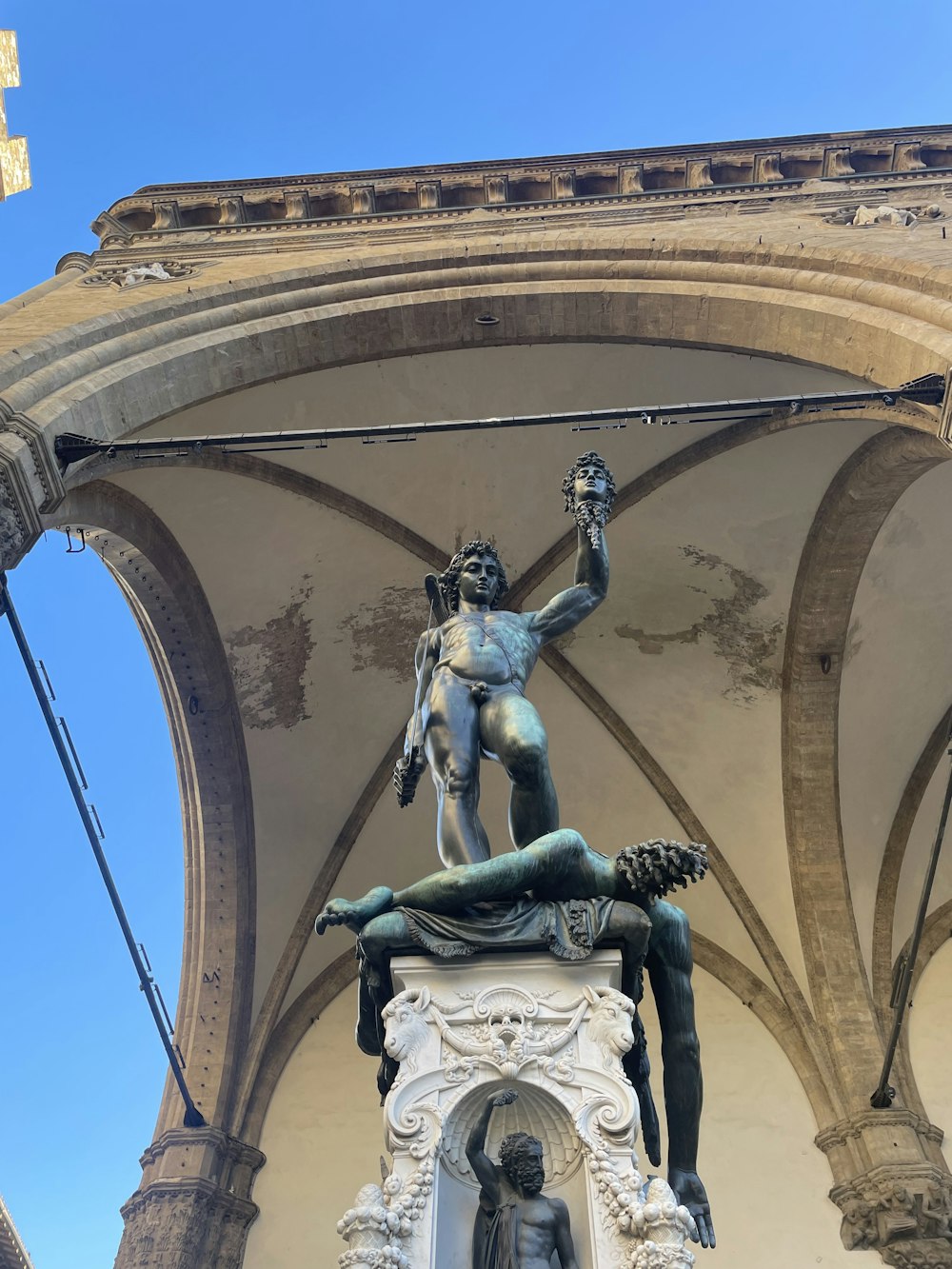 a statue of a person holding a staff in front of a building