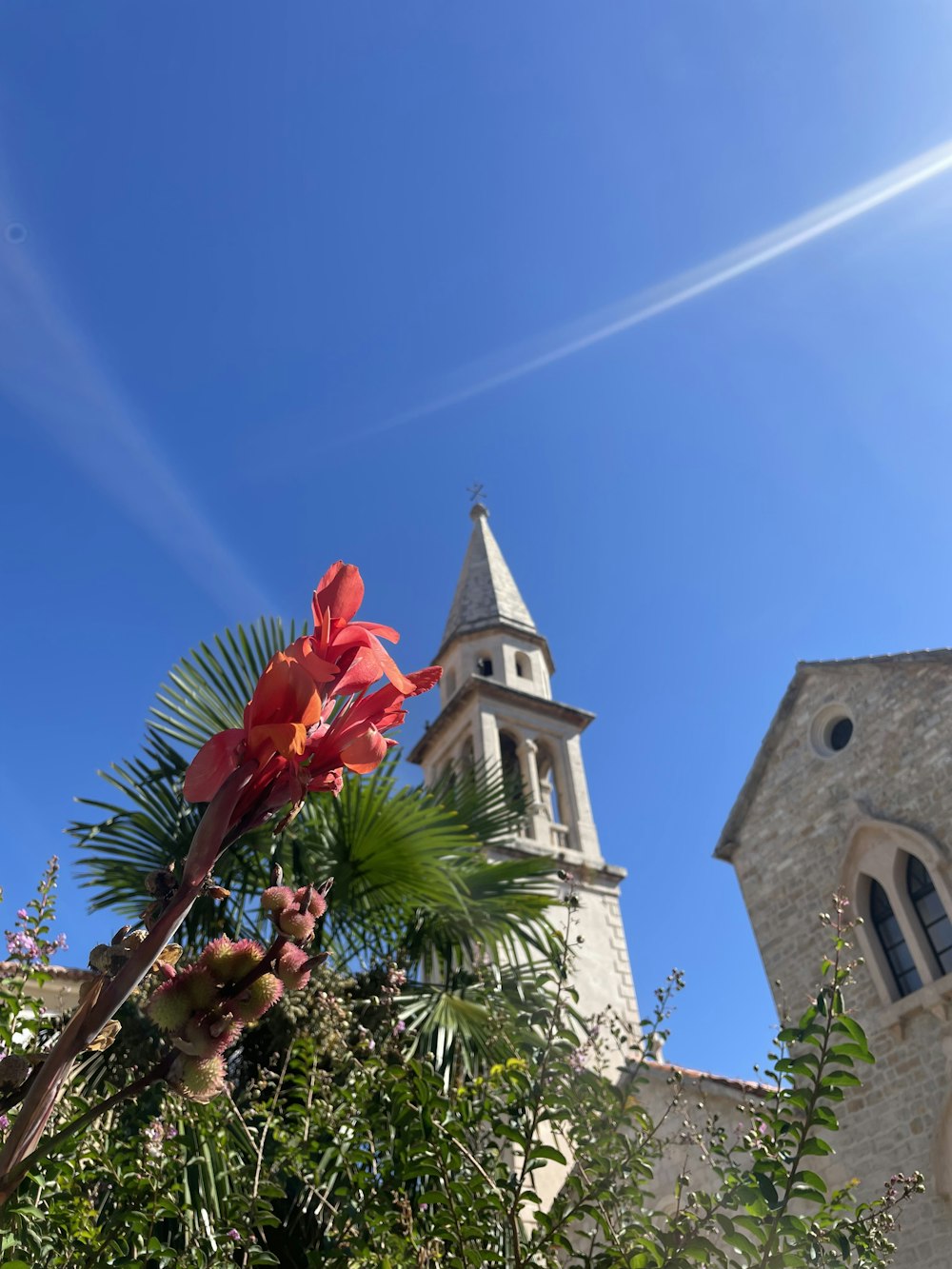 a white building with a tower and a blue sky