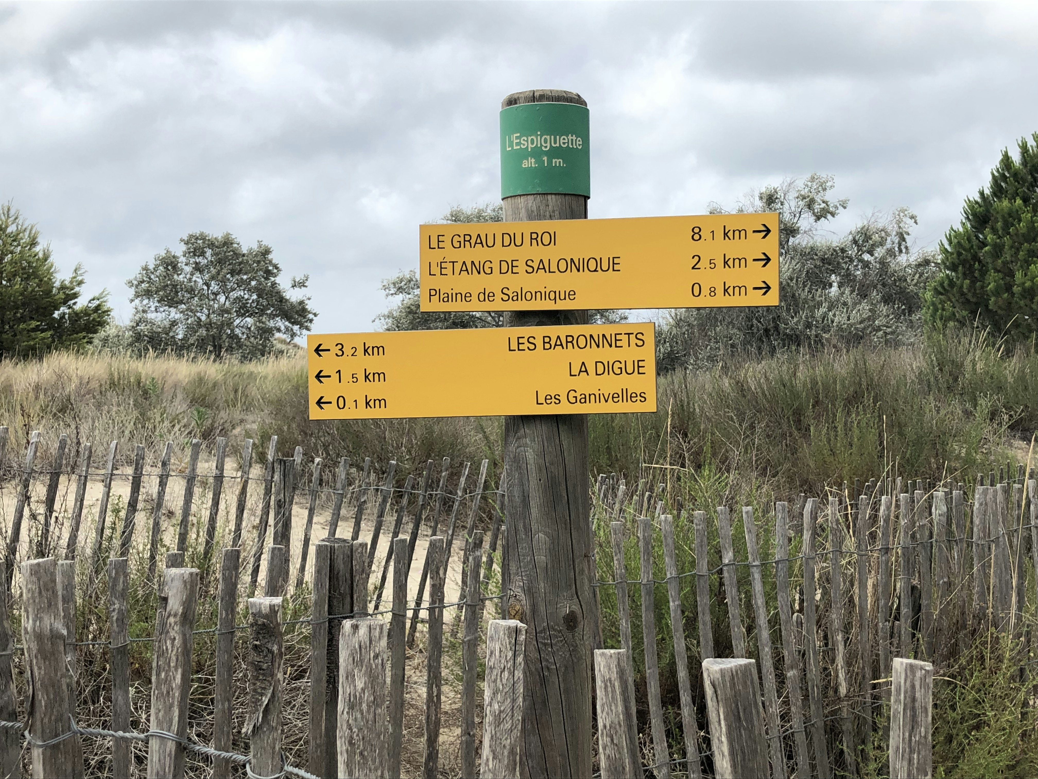 a sign post with a fence around it