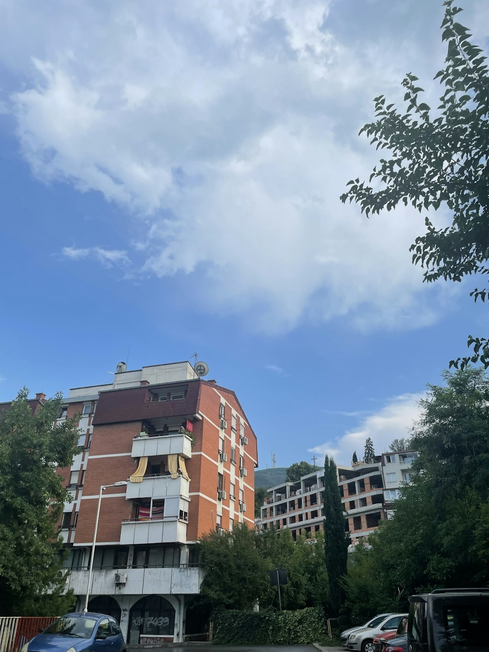 a building with trees and cars in front of it