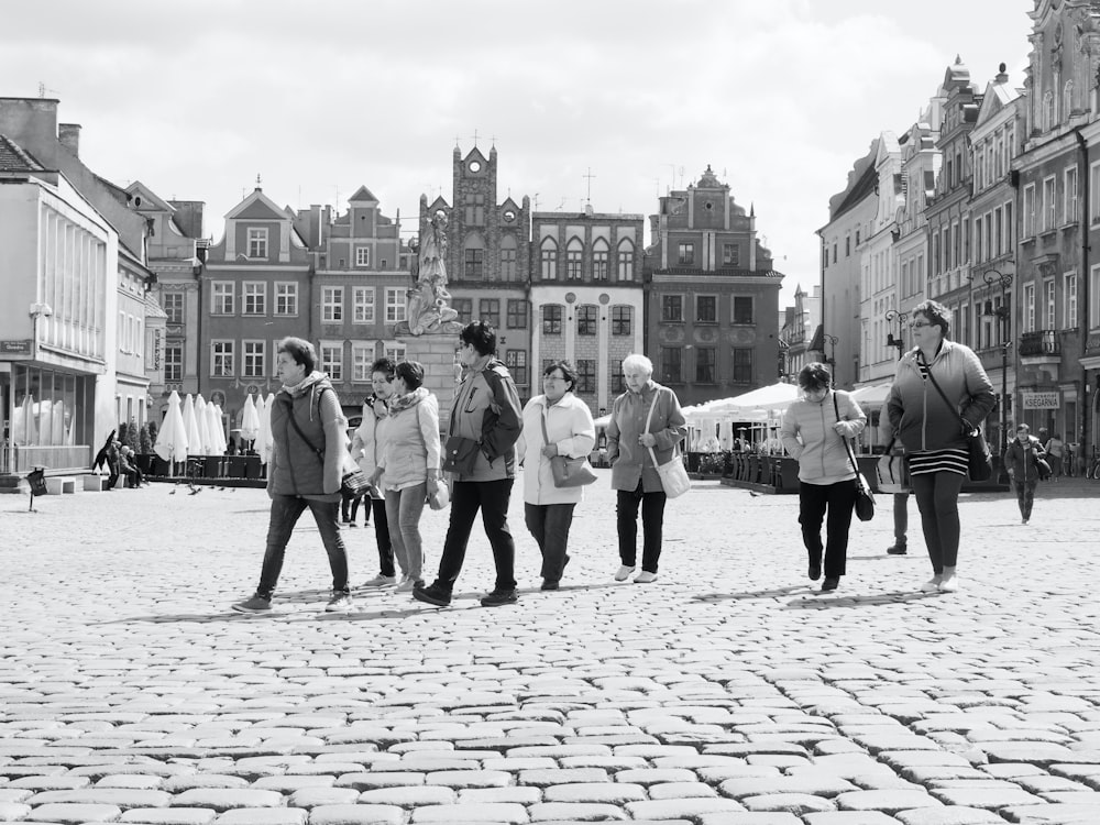 a group of people walking in a city square