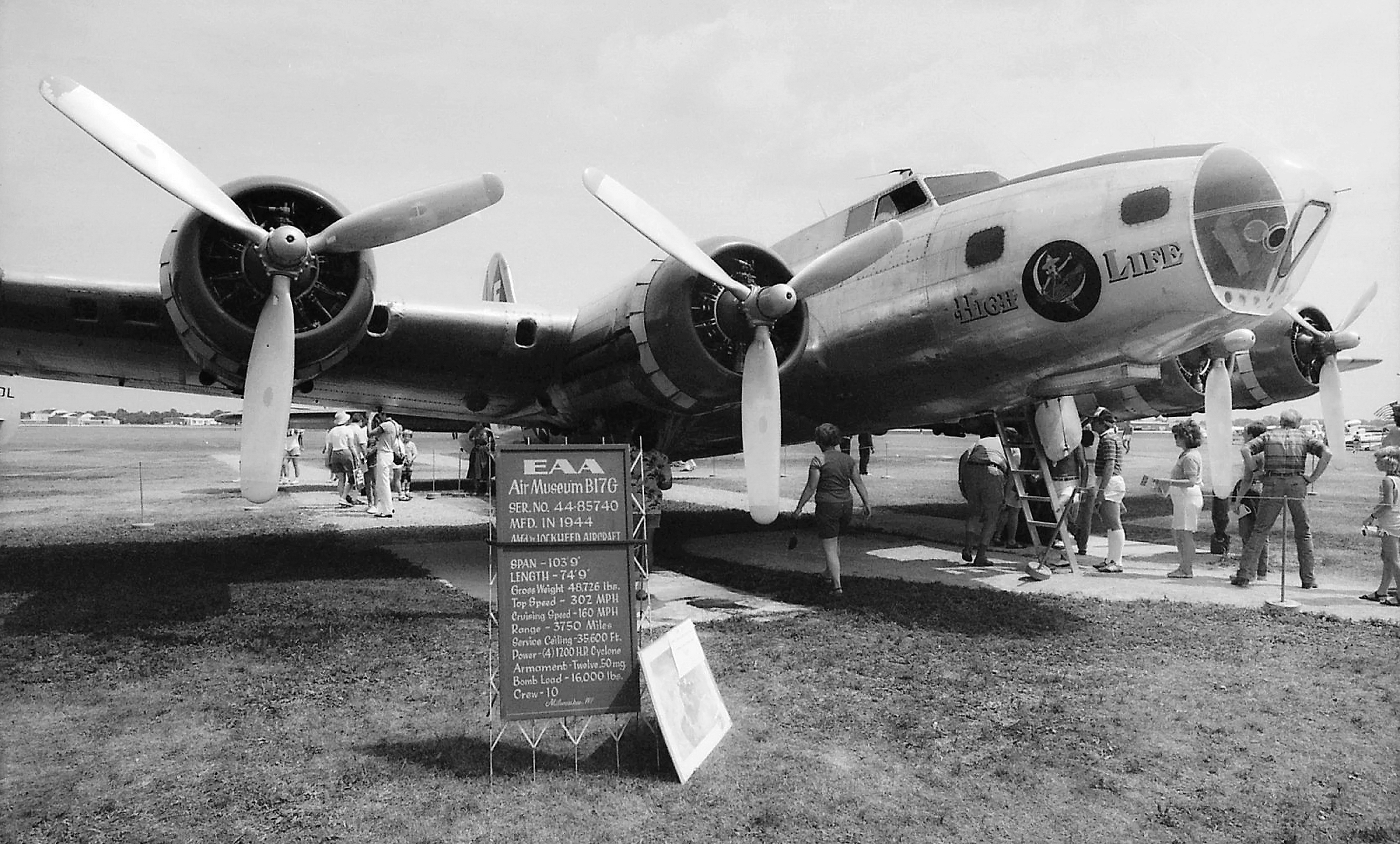 a group of people standing next to an airplane, American WW2 B-17 bomber. Photo was made from scanned 35mm film.