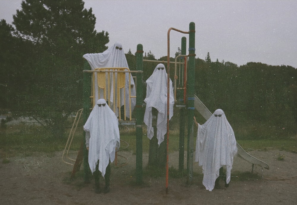 a group of people in white robes standing on a playground