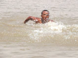 A triathlete powering through open water swim with determined focus.