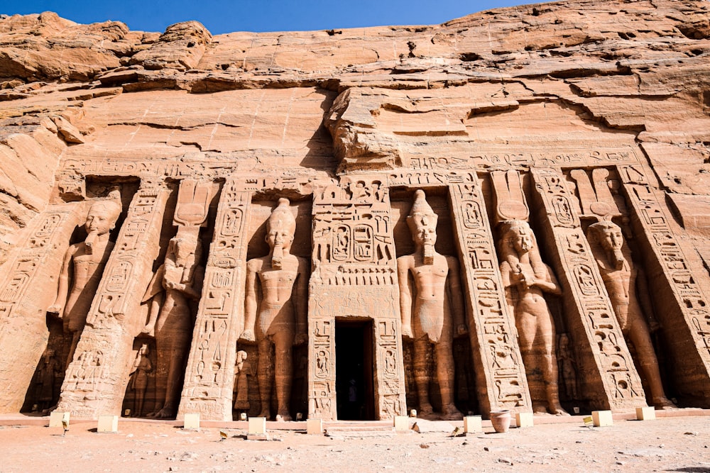 un gran edificio de piedra con templos de Abu Simbel al fondo