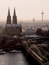 a bridge over a river with a city in the background