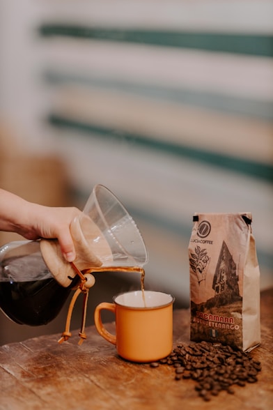 a person pouring a drink into a glass