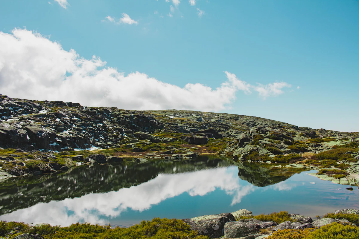 A pond among granite boulders on the high plateau of the Serra da Estrela, reflecting clouds