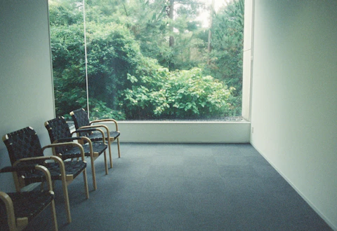 Consultorio con sillones junto a una ventana.
